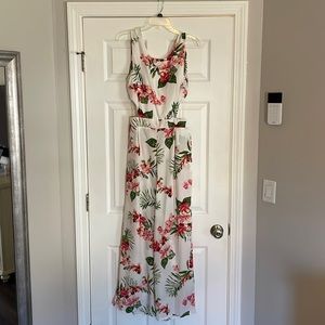 White floral jumpsuit. Size Large. Never Worn. Cut outs on side. Ties in back.